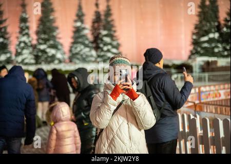 Moskau, Russland - 7. Januar 2022: Mädchen macht Fotos auf einem Smartphone auf dem Roten Platz in der Nähe des Kremls. Stockfoto