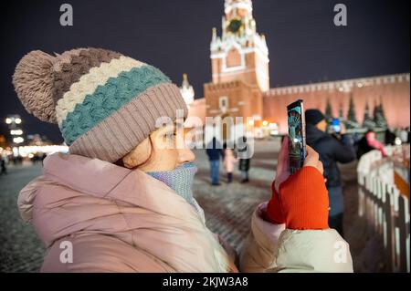 Moskau, Russland - 7. Januar 2022: Mädchen macht Fotos auf einem Smartphone auf dem Roten Platz in der Nähe des Kremls. Stockfoto