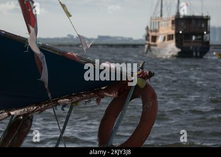 Ein Schiff überquert ein Holzschiff auf dem offenen Wasser Stockfoto