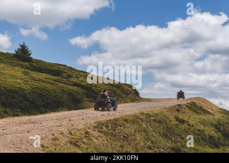Leute, die Quad Bikes auf Mountain Hill fahren Stockfoto