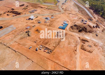 Eine Luftaufnahme einer großen Baustelle, auf der Erdbewegungsmaschinen und Traktoren für schwere Maschinen eingesetzt werden Stockfoto