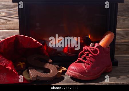 Saint Nicholas - Sinterklaas shoe with carrot and sweets near the fireplace Stock Photo