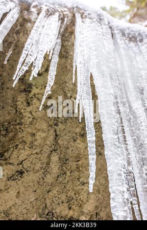 Eiszapfen-Kristall auf dem gefrorenen Stein. Im Freien und im Winter. Stockfoto