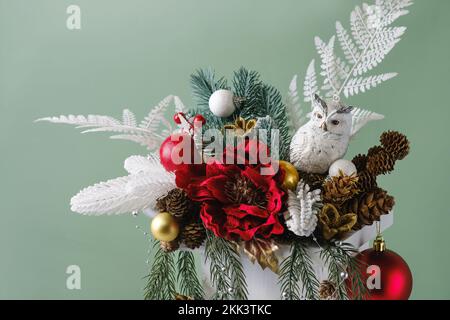 Weihnachtskomposition im Karton mit Fichte, Farn zur Tischdekoration. Verschneite Bälle mit Böschungen in schöner Verpackung, zusammengesetzt von einem Floristen Stockfoto