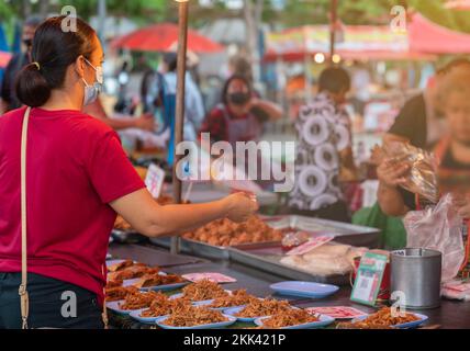 Eine Frau, die im Ewigkeiten Essen auf der Straße kauft. Asis-Markt. Stockfoto