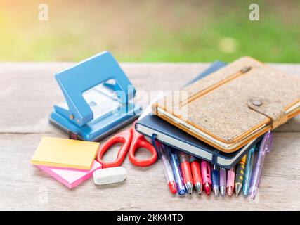 Stationäre und Notizbuchpaste auf Holztisch und unscharfem Hintergrund. Stockfoto