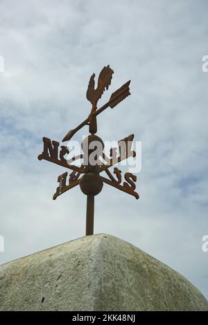 Eine Wetterfahne auf einem alten Steingebäude Stockfoto