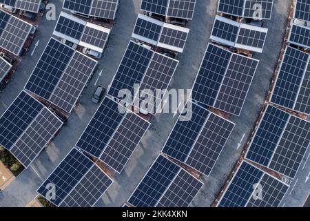 Luftaufnahme direkt über einem eigenständigen Parkplatz mit Solarpaneelen zum Aufladen von Elektroautos in einem innovativen Technologiebild Stockfoto