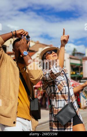 Ein junger Mann macht ein Foto, während seine Freundin zeigt, wo der Fokus liegen sollte Stockfoto