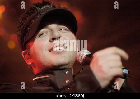 WESTLIFE, PEAK FAME, KONZERT, 2003: Mark Feehily von der irischen Boyband Westlife auf dem Höhepunkt ihres frühen Karriereerfolgs am 13. April 2003 in Cardiff CIA, Wales. Foto: Rob Watkins. INFO: Westlife, gegründet 1998 in Dublin, Irland, wurde zu einer der erfolgreichsten Boybands aller Zeiten. Ihre harmonischen Vocals und Balladen-getriebenen Popsongs fesselten das Publikum weltweit und brachten ihm zahlreiche Auszeichnungen und Auszeichnungen ein. Stockfoto