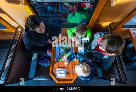 Oberwiesenthal, Deutschland. 25.. November 2022. Eine Familie testet das Spiel „Dampf ab!“ Während der Inbetriebnahme des neuen Wildwagens der Fichtelbergbahn. Es ist das erste Wildauto auf einer sächsischen Schmalspurbahn. Die sächsische Dampfeisenbahngesellschaft (SDG) investierte 11.500 Euro in die Umrüstung und Konstruktion des Autos. Kredit: Kristin Schmidt/dpa/Alamy Live News Stockfoto