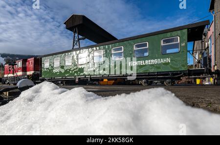 Oberwiesenthal, Deutschland. 25.. November 2022. Eine Lokomotive mit angebautem Spielzeugauto steht auf dem Gelände der Fichtelbergbahn in Oberwiesenthal. Es ist das erste Spielzeugauto auf einer sächsischen Schmalspurbahn. Die sächsische Dampfeisenbahngesellschaft (SDG) investierte 11.500 Euro in die Umrüstung und Gestaltung des Beförderungsmittels. Kredit: Kristin Schmidt/dpa/Alamy Live News Stockfoto