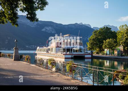 Annecy - der See, die Promenade und das Schiff auf dem See im Morgenlicht. Stockfoto