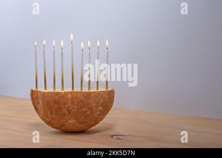 Kreatives Brot Hanukka Menorah auf einem Holztisch. Stockfoto