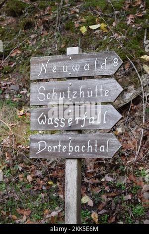 Verwittertes Holzschild zu Wanderwegen und Orten Stockfoto