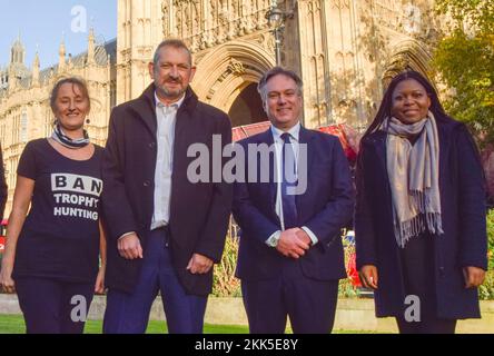 London, Großbritannien. 25.. November 2022 Konservativer Abgeordneter Henry Smith (zweiter von rechts), Eduardo Goncalves, Gründer der Kampagne zum Verbot der Trophäenjagd (zweiter von links), Nomusa Dube, Gründer der simbabwischen Elefantenstiftung, und ein Aktivister stehen nach der Debatte über das Gesetz über die Jagdtrophäen (Importverbot) vor dem Parlament; Mit dem die Einfuhr von Jagdtrophäen nach Großbritannien verboten werden soll. Kredit: Vuk Valcic/Alamy Live News Stockfoto