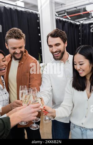 Fröhliche Geschäftsleute, die während einer Firmenfeier Champagner klingeln Stockfoto