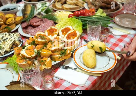 Auf dem Banketttisch gab es viele verschiedene Speisen und es gab gekochte Kartoffeln mit Dill. Eine große Anzahl an fertig zubereiteten Gerichten auf dem Tisch. Urlaub im Stockfoto