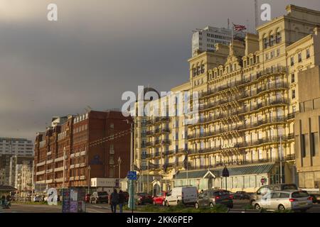 Große Hotels am Meer in Brighton in East Sussex, England. Das Hilton Metropole und das Grand. Im Abendlicht. Mit Leuten, die herumlaufen. Stockfoto