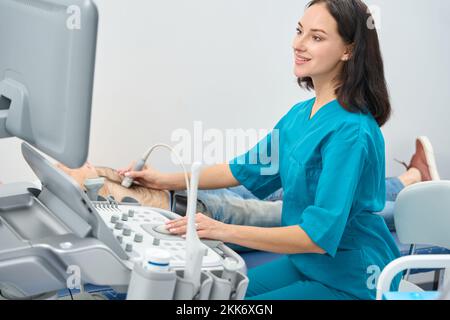 Frau führt eine Ultraschalluntersuchung der Bauchorgane des Menschen durch Stockfoto