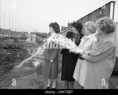 1980er, historisch, eine Verkäuferin, die einer älteren Dame mit einem Blumenstrauß und ihren Freunden zeigt, dass ihr Haus auf einem Wohnhaus in Leicestershire, England, errichtet wurde. Stockfoto