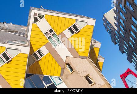 Holland, Rotterdam, The Cube Houses, ein innovatives Wohngebäude, bei dem jedes Haus ein um 45 Grad geneigter Würfel ist, entworfen vom niederländischen Architekten Piet Blom und Bult zwischen 1977 und 1984, mit Blick auf den Apartmentblock und Willemsbrug oder William's Bridge im Hintergrund. Stockfoto