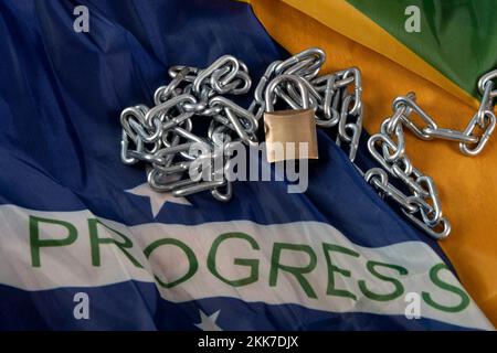 Kette, Vorhängeschloss und brasilianische Flagge symbolisieren die Sklaverei im Land Stockfoto