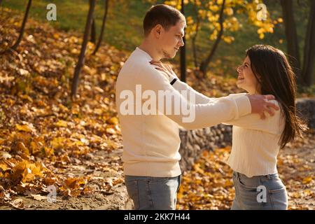 Fröhlicher Kerl und seine Freundin stehen Seite an Seite Stockfoto