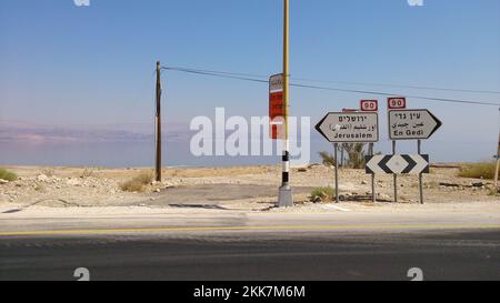 Ein Straßenschild, das an einem sonnigen Tag nach Jerusalem und zum Toten Meer führt Stockfoto