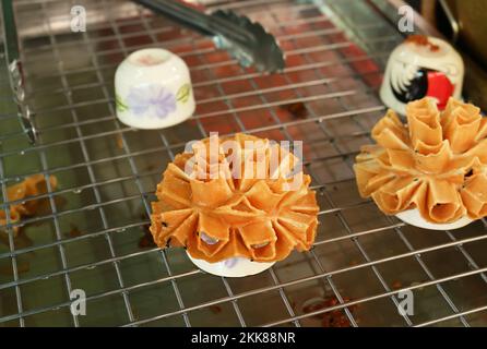Frisch gebratene, blumige, traditionelle thailändische Desserts namens Kanom Dokchok oder Pistia Flower Sweets Stockfoto