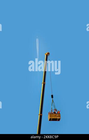 Frankfurt, Deutschland - 23. August 2009: Kondensationsspur am blauen Himmel, die Menschen sind glücklich in einem Ballonauto, das von einem riesigen Kran angehoben wird Stockfoto