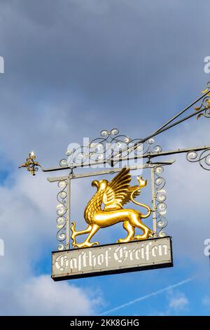 Rothenburg ob der Tauber, Deutschland - 15. Januar 2014: Mittelalterliche Ladenbeschilderung Gasthof Greifen engl: Restaurant Griffon , mit goldenem Greifsymbol Stockfoto