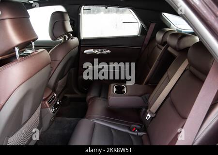 Modernes Auto im Innenraum. Beifahrersitze in Leder mit geöffneter Armlehne. Komfortable Ledersitze. Mittlere Armlehne für Rücksitz Stockfoto
