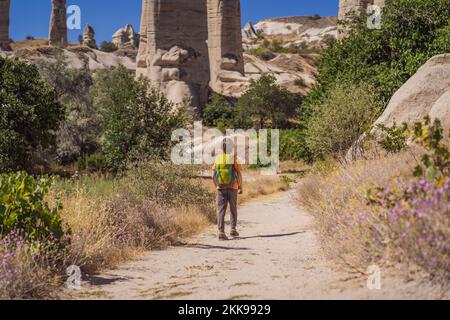 Junge Touristen vor dem Hintergrund einzigartiger geologischer Formationen im Love Valley in Kappadokien, einem beliebten Reiseziel in der Türkei. Reisen mit Kindern Stockfoto