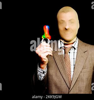 Geschäftsmann, der eine Strumpfmaske über dem Kopf trägt, hält einen bunt gestreiften Süßigkeitendummy hoch und grinst an der Leichtigkeit, mit der er ihn gestohlen hat, CO Stockfoto