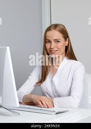 Lächelnde junge Ärztin, die mit ihrem Computer arbeitet Stockfoto