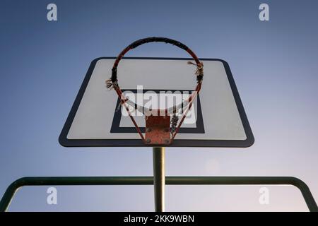 Basketballkorb mit Rückwand und blauem Himmel Stockfoto