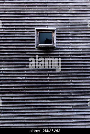 Kleines quadratisches Einzelfenster in einem Gebäude mit moderner Architektur. Horizontale Leuchten. Falmouth Hafen. Stockfoto