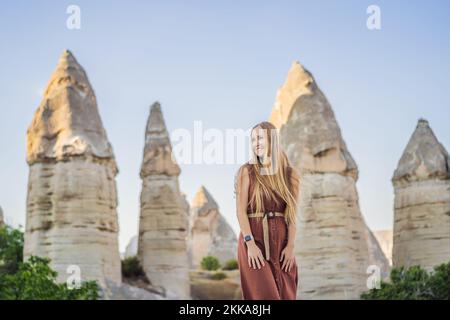Touristin vor dem Hintergrund einzigartiger geologischer Formationen im Love Valley in Kappadokien, einem beliebten Reiseziel in der Türkei Stockfoto