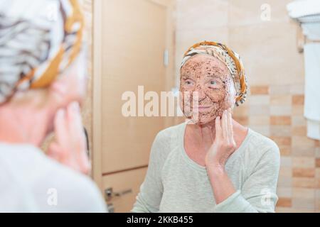 Ältere Frau, die sich um ihr Gesicht kümmert Stockfoto