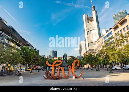 Frankfurt, Deutschland - 23. Juli 2019: Blick auf die Skyline von Frankfurt mit dem berühmten Wolkenkratzer der wichtigsten europäischen Banken und Skulpturenliebe Stockfoto