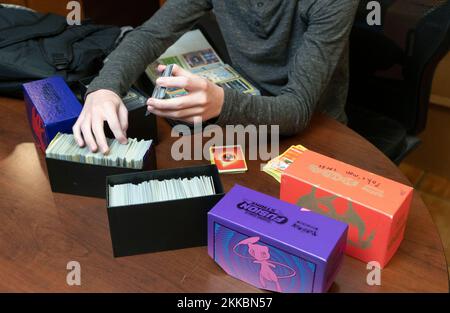 Austin Texas, USA, November 24 2022: Ein 14-jähriger Junge sortiert seine Pokemon-Kartensammlung während einer Pause in Thanksgiving-Dinner-Aktivitäten im Haus eines Verwandten. ©Bob Daemmrich Stockfoto