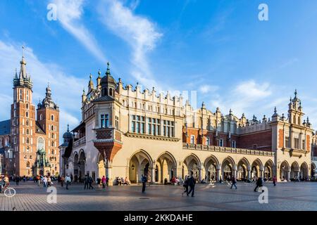 KRAKAU, POLEN - 7. Okt 2014: Menschen auf dem Hauptmarkt in der Nähe von Sukiennice, Tuchhalle und Rathausturm. Der Tuchsaal wurde im 14. Jahrhundert erbaut Stockfoto