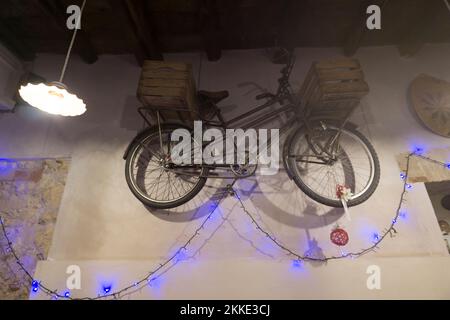 An der Wand hängt ein Fahrrad mit Weihnachtslichtern Stockfoto