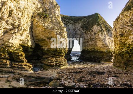 Ebbe in Selwicks Bay, Flamborough Head. Dieser Strand ist voller interessanter Felsformationen in den Klippen, hier einer der Klippenbögen. Stockfoto
