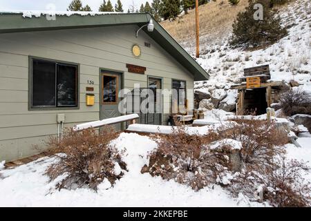 Boulder, Montana, USA. 25.. November 2022. Der Eingang zur Sunshine Radon Mine (rechts), eine von einer Handvoll „Gesundheitsminen“ in Montana, die vorgeben, Krankheiten mit dem Radongas zu heilen, das aus den Wänden dieser veralteten Uranminen sickert. Radon ist ein tödliches Gas, wenn es in ausreichenden Mengen eingeatmet wird; einige Befürworter der „natürlichen Heilung“ und der Theorie der Strahlungshormesis, darunter viele in den Amischen und Mennoniten, glauben jedoch entgegen der Überlegenheit wissenschaftlicher Beweise, dass kleinere Dosen von Radon Krankheiten heilen können. Die Minen sind für den Winter geschlossen Stockfoto