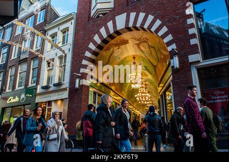 Amsterdam, Niederlande. 25.. November 2022. Man sieht Leute, die vor einer der Gänge voller Geschäfte vorbeigehen. In Amsterdam gibt es Geschäfte mit Angeboten und die Schaufenster sind mit Verkaufsbannern dekoriert, um die Besucher am Black Friday anzuziehen, da sich die Niederlande in einer milden Rezession befinden. (Foto: Ana Fernandez/SOPA Images/Sipa USA) Guthaben: SIPA USA/Alamy Live News Stockfoto