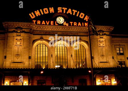 Union Station in Denver, Colorado, bei Nacht, da das Schild orange leuchtet und den dunklen Himmel durchdringt. Stockfoto