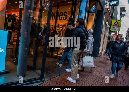 Amsterdam, Niederlande. 25.. November 2022. Man sieht Leute, die mit Sonderverkäufen in eines der Geschäfte gehen. In Amsterdam gibt es Geschäfte mit Angeboten und die Schaufenster sind mit Verkaufsbannern dekoriert, um die Besucher am Black Friday anzuziehen, da sich die Niederlande in einer milden Rezession befinden. (Foto: Ana Fernandez/SOPA Images/Sipa USA) Guthaben: SIPA USA/Alamy Live News Stockfoto