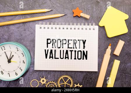 Text zur Bewertung des Hotels auf Notizblock mit Hausmodell und Schlüssel auf Holzschreibtisch Stockfoto